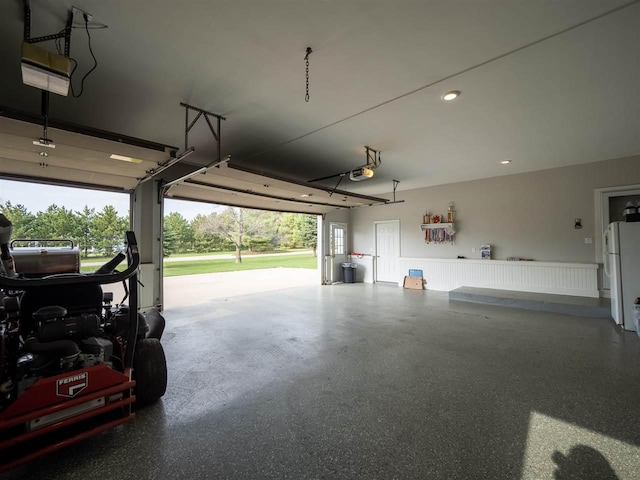 garage featuring a garage door opener and white fridge