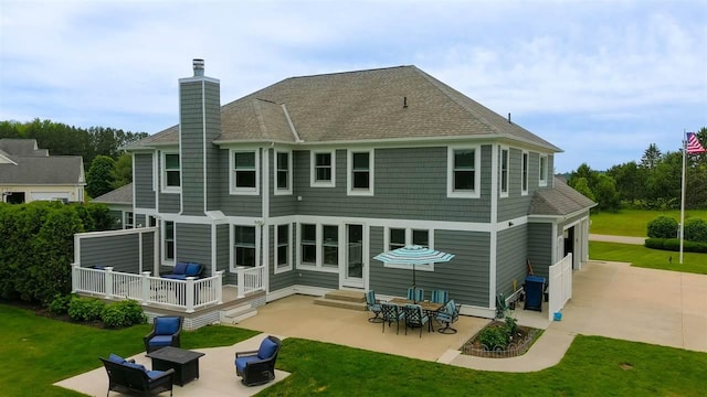 back of property featuring an outdoor living space, a patio, and a lawn