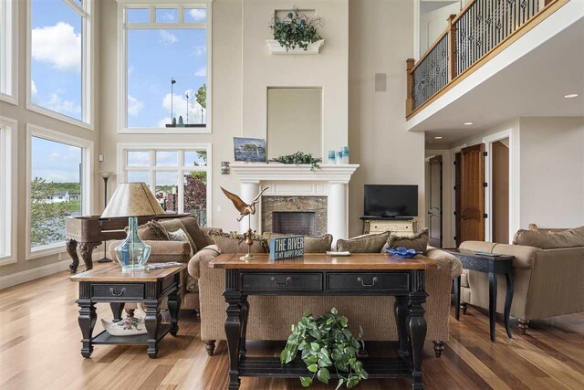 1439 Lindburgh Ln, Cheboygan, MI 49721 - living area with a towering ceiling, wood finished floors, a high end fireplace, and healthy amount of natural light