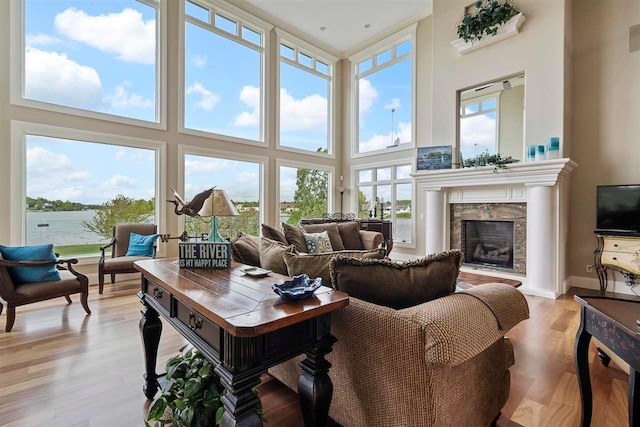 living room with a towering ceiling, a healthy amount of sunlight, and hardwood / wood-style floors