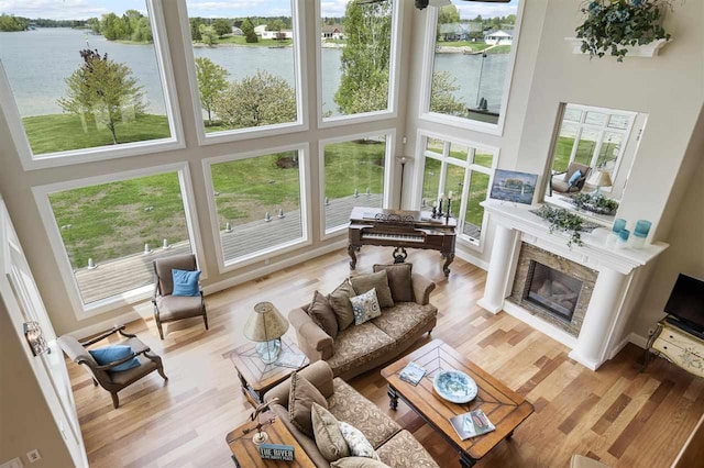 1439 Lindburgh Ln, Cheboygan, MI 49721 - living room featuring a water view, a towering ceiling, a fireplace, and wood finished floors