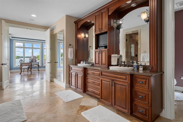 bathroom featuring an enclosed shower, oversized vanity, dual sinks, and tile floors