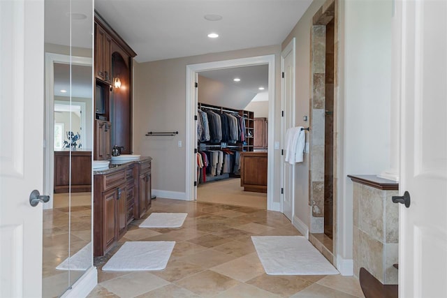 bathroom with tile floors, walk in shower, and vanity with extensive cabinet space