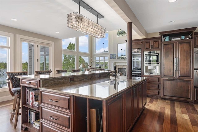 1439 Lindburgh Ln, Cheboygan, MI 49721 - kitchen featuring healthy amount of natural light, a fireplace, light wood-style floors, an island with sink, and recessed lighting