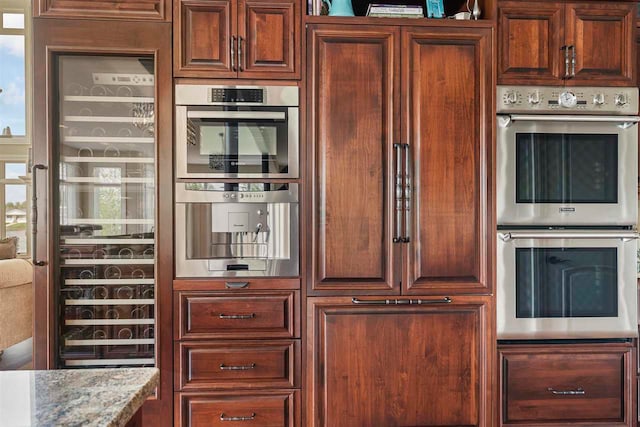 kitchen with double oven and light stone counters