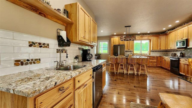 kitchen featuring dark hardwood / wood-style floors, appliances with stainless steel finishes, sink, and a center island