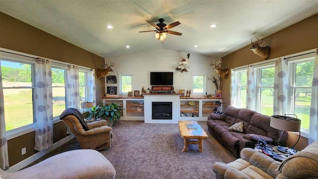 carpeted living room with ceiling fan, vaulted ceiling, and a textured ceiling