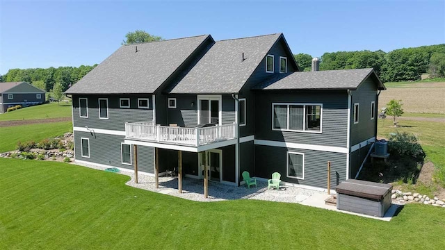 back of house featuring a patio area, a wooden deck, a lawn, and central air condition unit