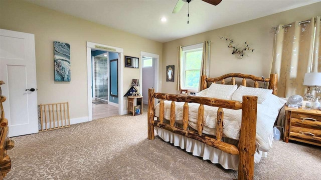 bedroom with ceiling fan, ensuite bath, and carpet flooring