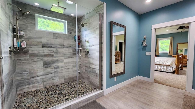 bathroom with ceiling fan, hardwood / wood-style floors, and walk in shower