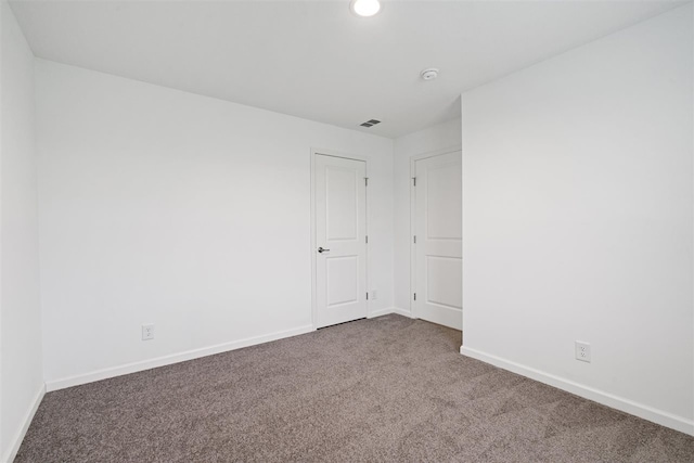 unfurnished room featuring dark carpet