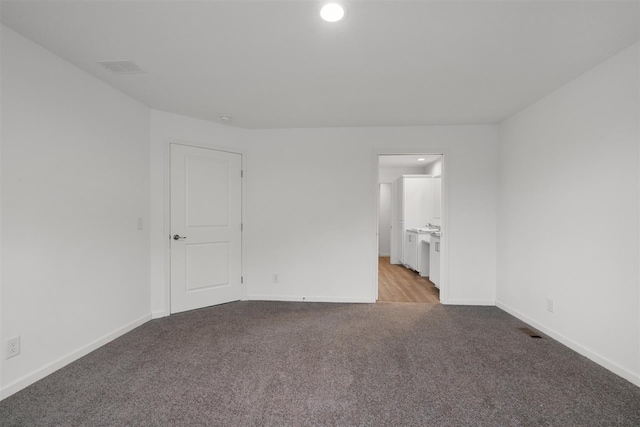 unfurnished bedroom featuring carpet flooring and connected bathroom