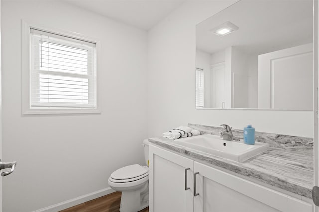 bathroom featuring wood-type flooring, toilet, and vanity