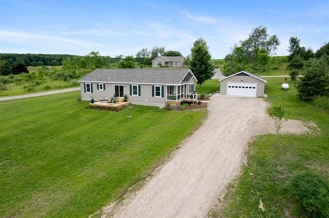 single story home with a garage, a front yard, and an outdoor structure