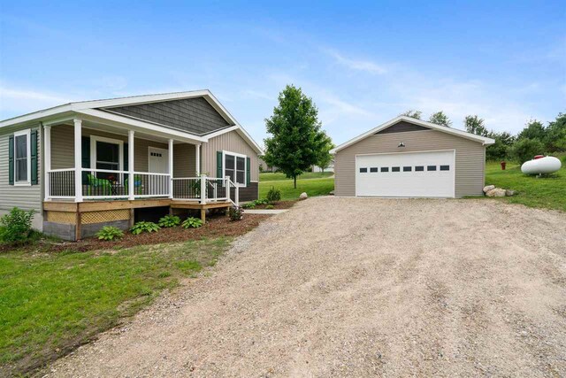 view of front of property featuring covered porch, an outdoor structure, and a garage