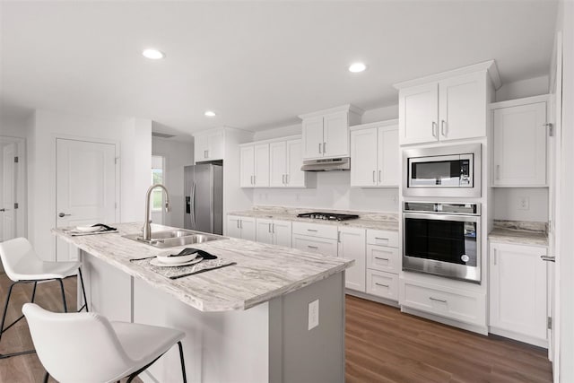 kitchen featuring a kitchen island with sink, dark wood-type flooring, white cabinets, sink, and appliances with stainless steel finishes