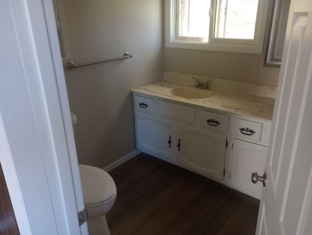 bathroom with hardwood / wood-style floors, vanity, and toilet