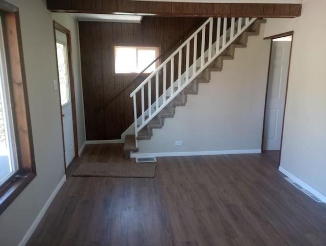 foyer featuring dark hardwood / wood-style floors and wood walls