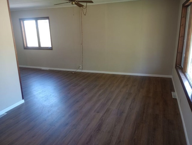 empty room with ceiling fan and dark wood-type flooring