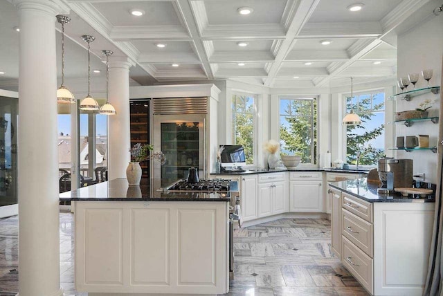 kitchen with plenty of natural light, white cabinets, dark stone counters, and beamed ceiling