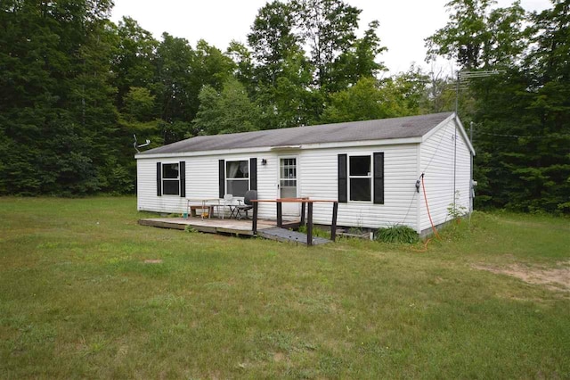 back of property with a lawn and a wooden deck