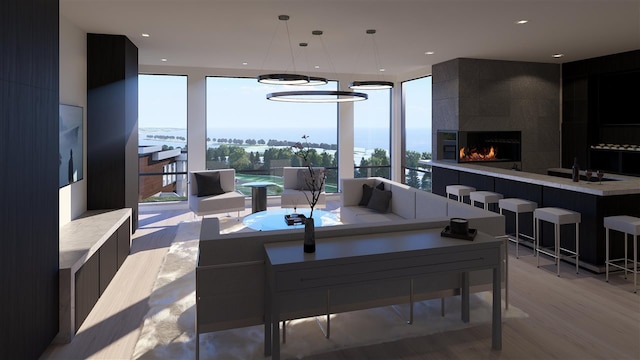 interior space featuring a tile fireplace, a water view, and light hardwood / wood-style flooring