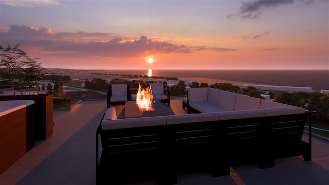 patio terrace at dusk with a water view and an outdoor living space with a fire pit