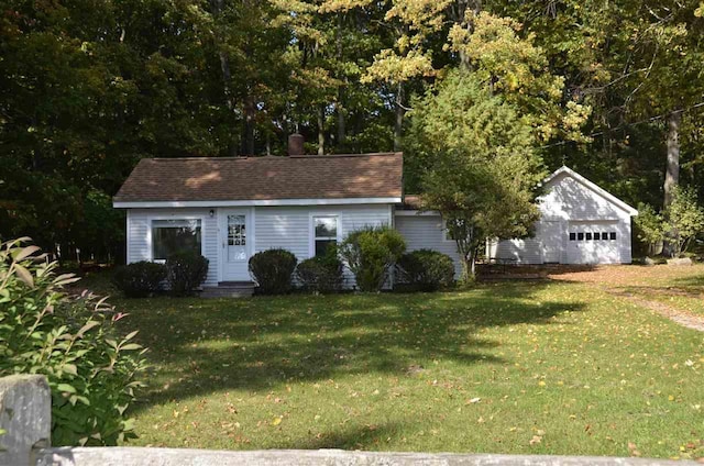 view of front of home featuring a garage, an outdoor structure, and a front yard