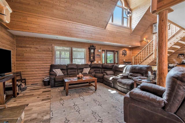 living room with log walls, light hardwood / wood-style flooring, wood ceiling, decorative columns, and high vaulted ceiling