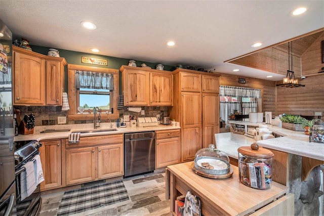 kitchen featuring sink, appliances with stainless steel finishes, hanging light fixtures, and decorative backsplash