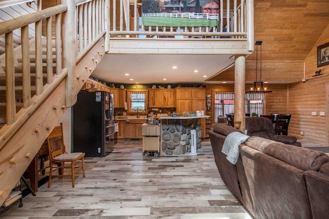 living room with high vaulted ceiling and light hardwood / wood-style flooring