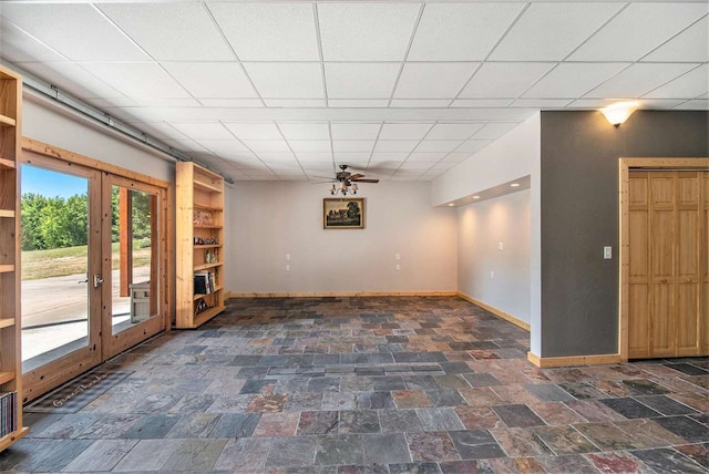 tiled spare room with a drop ceiling, french doors, and ceiling fan