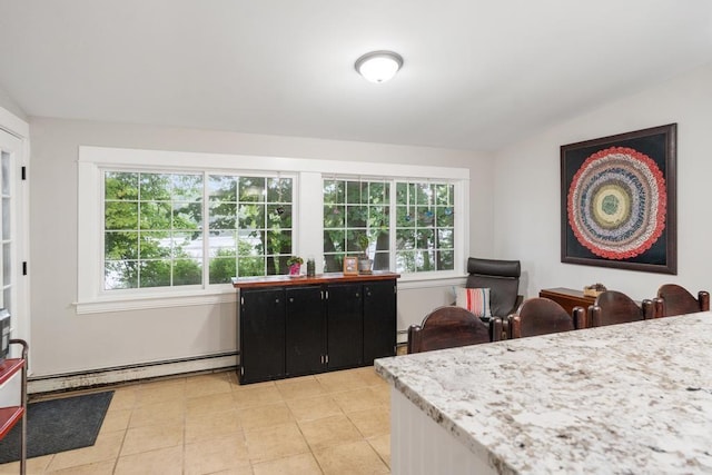 kitchen with lofted ceiling, light tile patterned floors, a wealth of natural light, and baseboard heating