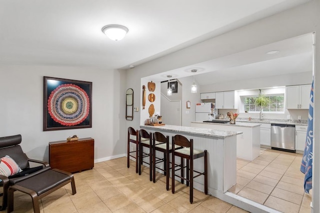 kitchen featuring a breakfast bar area, dishwasher, white refrigerator, white cabinets, and decorative light fixtures