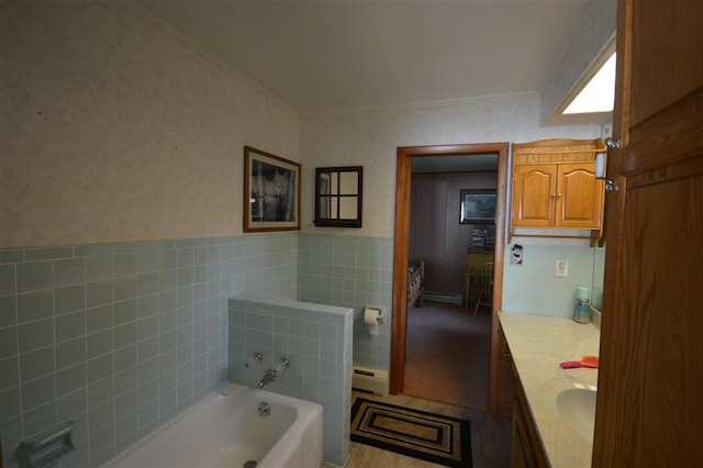 bathroom featuring vanity, a washtub, a baseboard heating unit, and tile walls