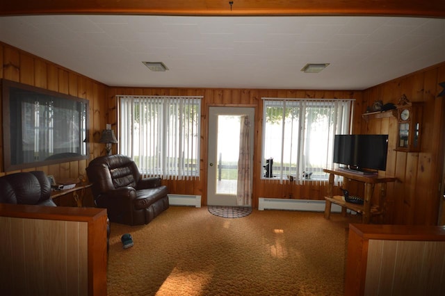 carpeted living room with wood walls and baseboard heating