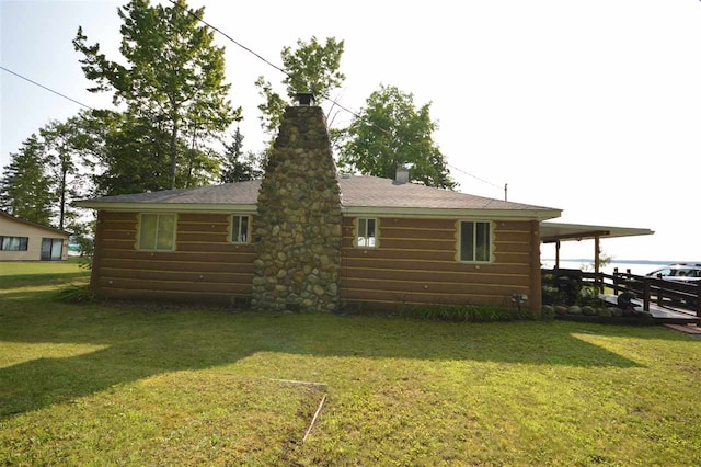 rear view of property featuring a lawn