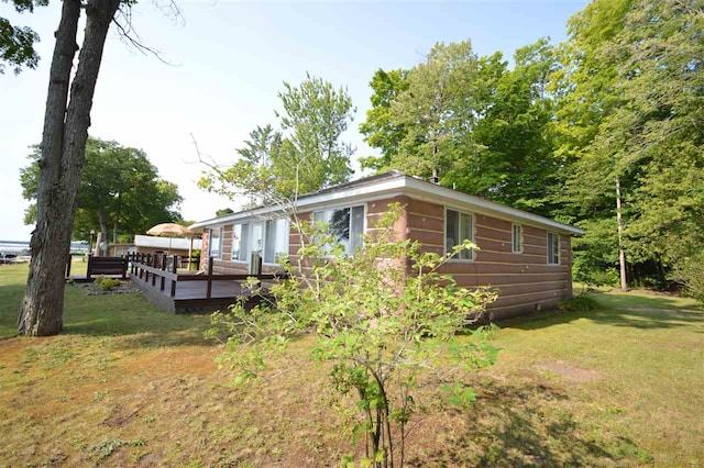 exterior space with a deck and a front lawn