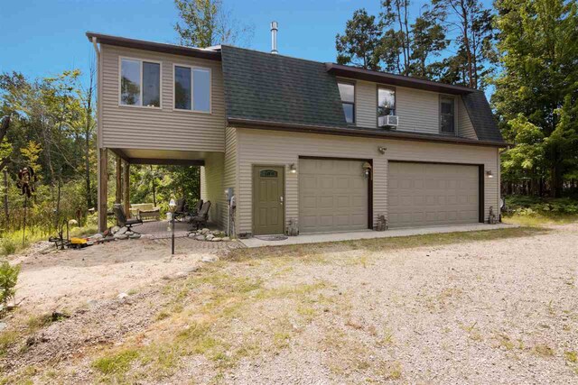 view of front of property featuring cooling unit and a garage