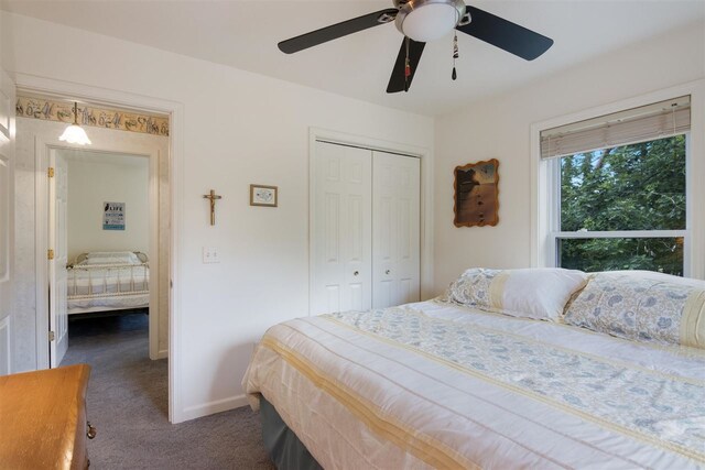 bedroom with dark carpet, ceiling fan, and a closet