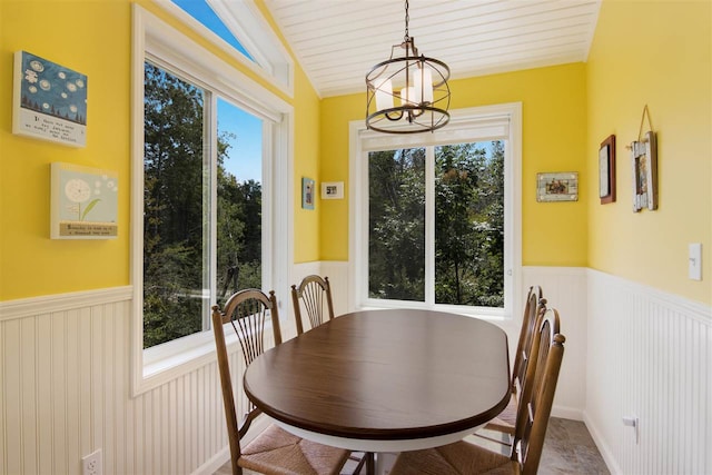 dining area featuring lofted ceiling, a healthy amount of sunlight, and an inviting chandelier