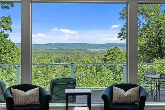 balcony featuring a wooded view and a mountain view