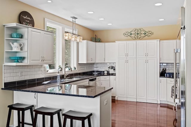 kitchen with dark stone counters, a peninsula, open shelves, and white cabinets