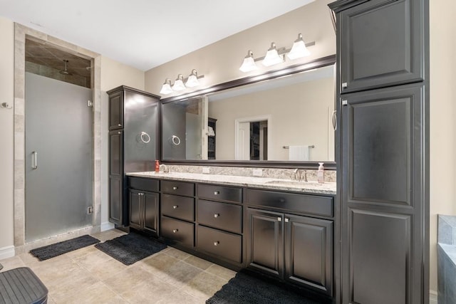 bathroom with double vanity, a stall shower, tile patterned flooring, and a sink