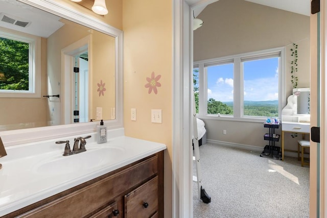 ensuite bathroom with baseboards, visible vents, lofted ceiling, ensuite bathroom, and vanity