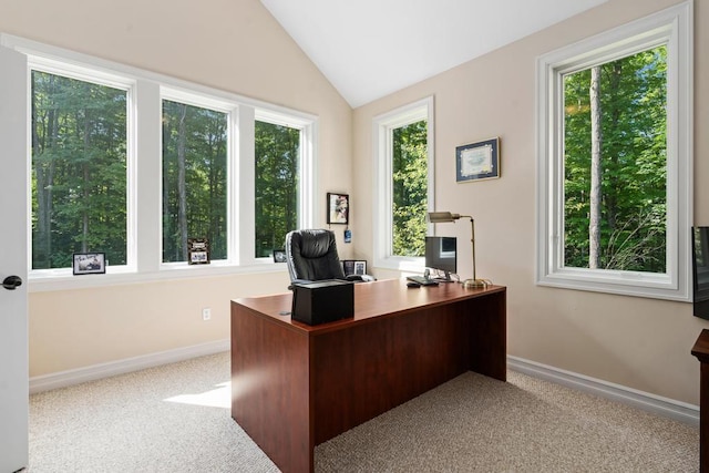 office space with light carpet, baseboards, lofted ceiling, and a healthy amount of sunlight