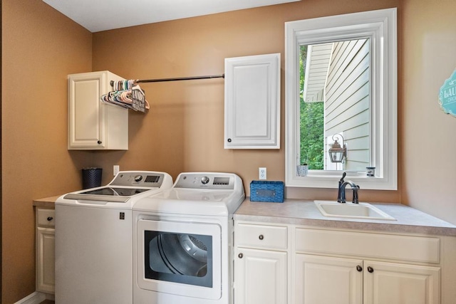 washroom featuring washing machine and clothes dryer, a sink, and cabinet space