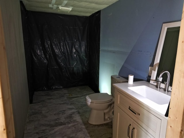 bathroom featuring tile patterned flooring, toilet, and vanity