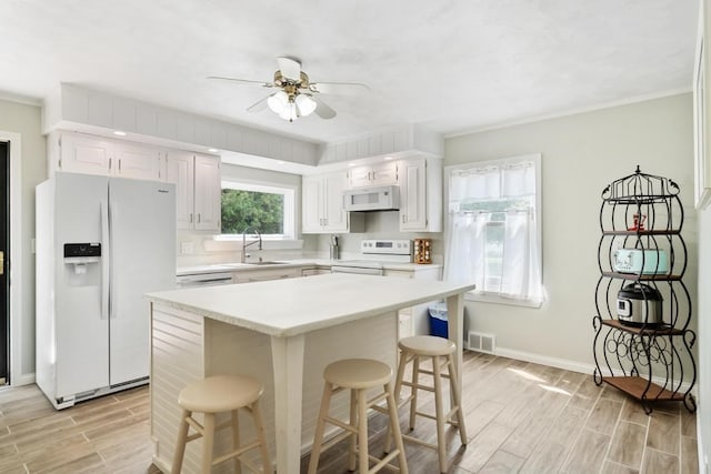 kitchen with white cabinetry, white appliances, sink, and ceiling fan