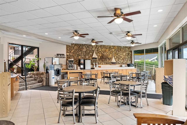 tiled dining room featuring ceiling fan and a paneled ceiling